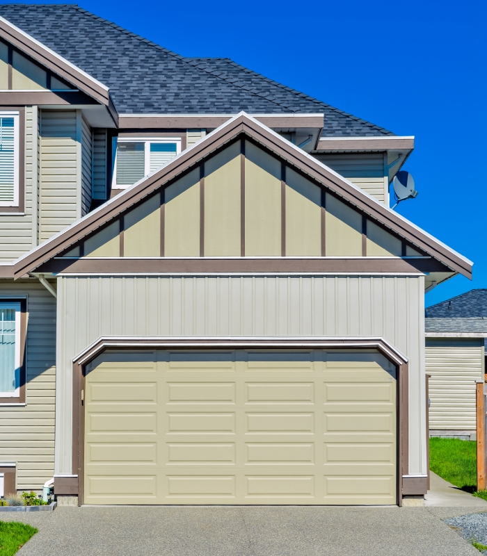 Porte de garage sectionnelle blanche installée sur une maison contemporaine